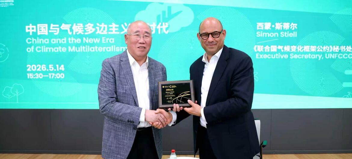 联合国气候变化框架公约执行秘书西蒙·斯蒂尔在北京举行的气候多边主义活动中从前中国特使手中接过奖项。