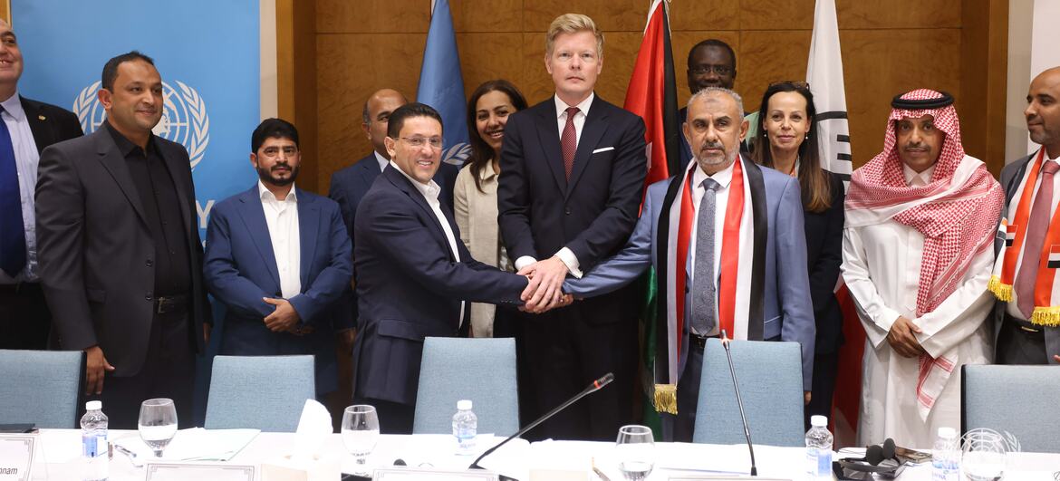 Heads of delegations from the Government of Yemen (right) and the Houthis (left) shake hands after signing an agreement to release over 1,600 conflict-related detainees under the auspices of the United Nations Special Envoy for Yemen (centre).