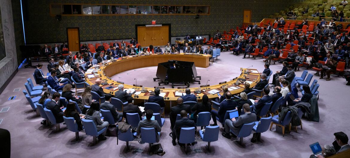 Wide view of the UN Security Council meeting discussing the situation in Iran, with delegates seated around a large circular table.