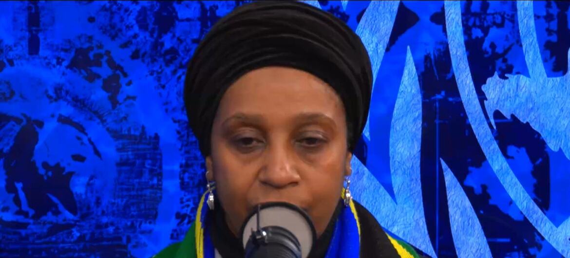 Mwanamke aliyevaa hijabu na mshipi wenye rangi za bendera ya Tanzania akizungumza kwenye kipaza sauti katika tukio la Umoja wa Mataifa.