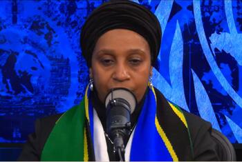 Mwanamke aliyevaa hijabu na mshipi wenye rangi za bendera ya Tanzania akizungumza kwenye kipaza sauti katika tukio la Umoja wa Mataifa.