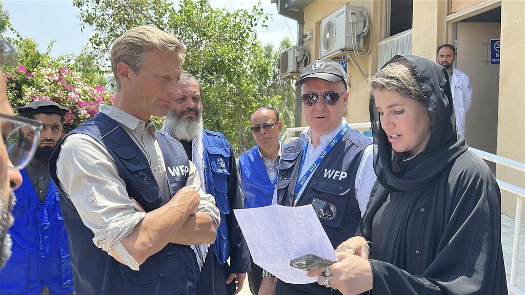 Le directeur exécutif adjoint du PAM, Carl Skau, et d'autres responsables examinent des documents avec des rapatriés au centre de transit de Torkham en Afghanistan.