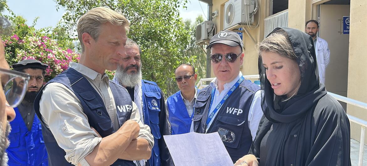 O Diretor Executivo Adjunto do PMA, Carl Skau, e outros funcionários revisam documentos com os retornados no Centro de Trânsito de Torkham, no Afeganistão.