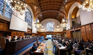 The International Court of Justice (ICJ) holds public hearings on the genocide case between The Gambia and Myanmar at the Peace Palace in The Hague, with judges seated at a long table and attendees in the audience.