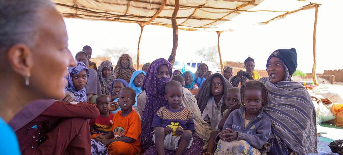 مجموعة من العائلات النازحة، بمن فيهم أطفال، تجلس تحت ملجأ في تاويلا، شمال دارفور، السودان. تتحدث فتاة شابة تدعى دوحا إلى أنماري سواي، نائبة ممثلة اليونيسف، عن تعليمها المتقطع وحلمها بأن تصبح مدرسة للغة الإنجليزية.