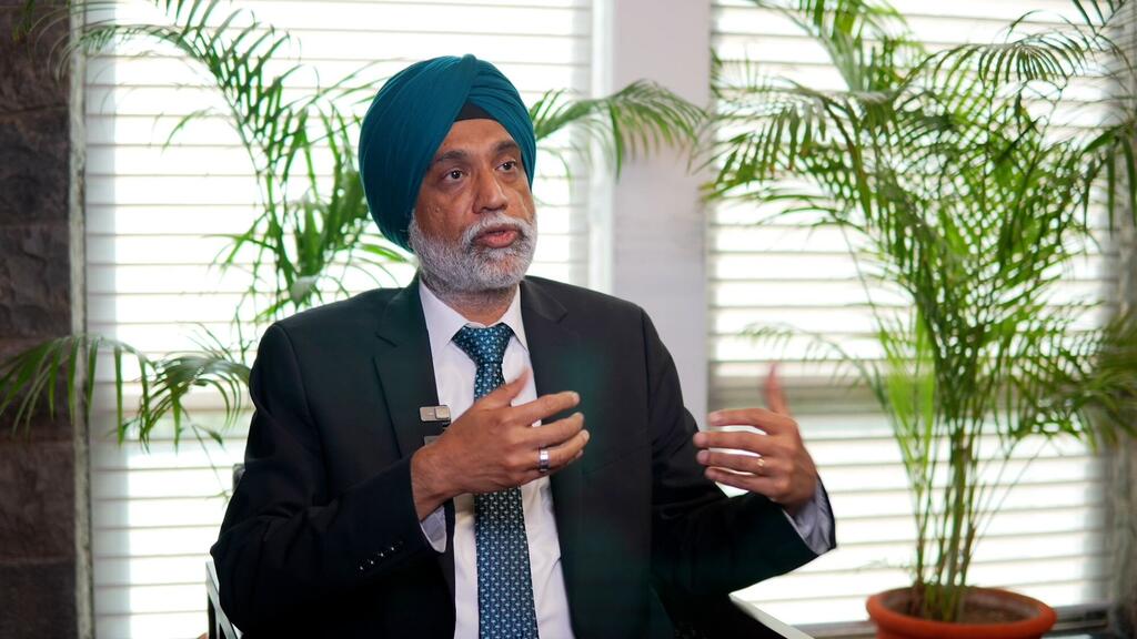 Deep Aman Gill, kiongozi wa kiteknolojia wa India aliyevaa turban ya bluu na suti, anaongea katika mkutano wa AI Summit USG, akiashiria kwa mikono yake.