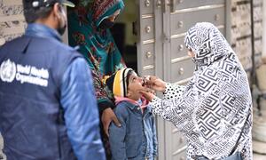 A WHO-trained polio worker administers a vaccine to a child in Pakistan during a national polio vaccination campaign in February 2026.