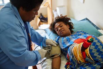 En Papouasie-Nouvelle-Guinée, un professionnel de la santé vérifie la pression artérielle d'une femme enceinte lors d'une visite de routine à la clinique.