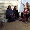La famille de M. Walid Al-Asi est assise à côté d'une tente dressée à côté de leur maison détruite à Al-Zarqa, dans la ville de Gaza, pendant le Ramadan.