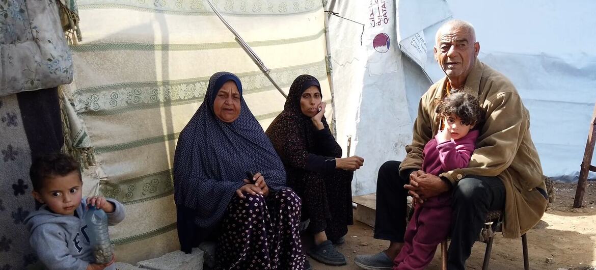 Mr. Walid Al-Asi's family sits beside a tent set up next to their destroyed home in Al-Zarqa, Gaza City, during Ramadan.