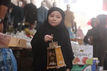 गाजा में एक युवा लड़की ने रमजान का एक सुशोभित लालटेन पकड़ा, मुस्कुराते हुए जब वह उत्सव समारोह में भाग लेती है।