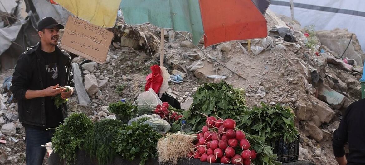 Um vendedor de rua em Gaza vende vegetais frescos, incluindo rabanetes e ervas, de um carrinho durante o Ramadã.