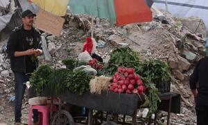 Un vendedor callejero en Gaza vende verduras frescas, incluyendo rábanos y hierbas, desde un carro durante el Ramadán.
