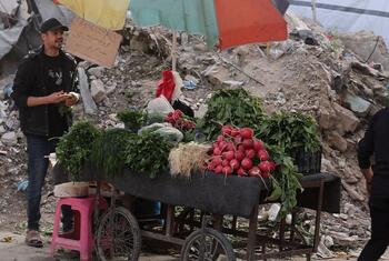 Un vendedor callejero en Gaza vende verduras frescas, incluyendo rábanos y hierbas, desde un carro durante el Ramadán.