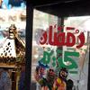Um close-up de uma lanterna do Ramadã decorada em Gaza, com caligrafia árabe e personagens coloridos de desenhos animados, simbolizando as tradições festivas do mês sagrado.