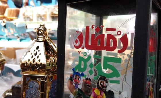 Picha ya karibu ya taa iliyopambwa ya Ramadhani huko Gaza, iliyo na maandishi ya Kiarabu na wahusika wa katuni wenye rangi, ikiwakilisha mila za sherehe za mwezi mtakatifu.