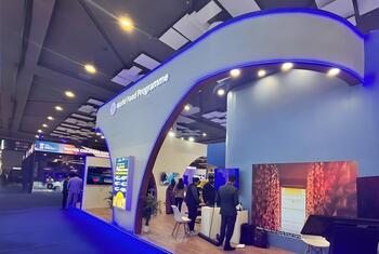 在印度举行的2024年人工智能峰会上,世界粮食计划展位,展示了现代蓝色道,数字显示器和参观者探索展览.