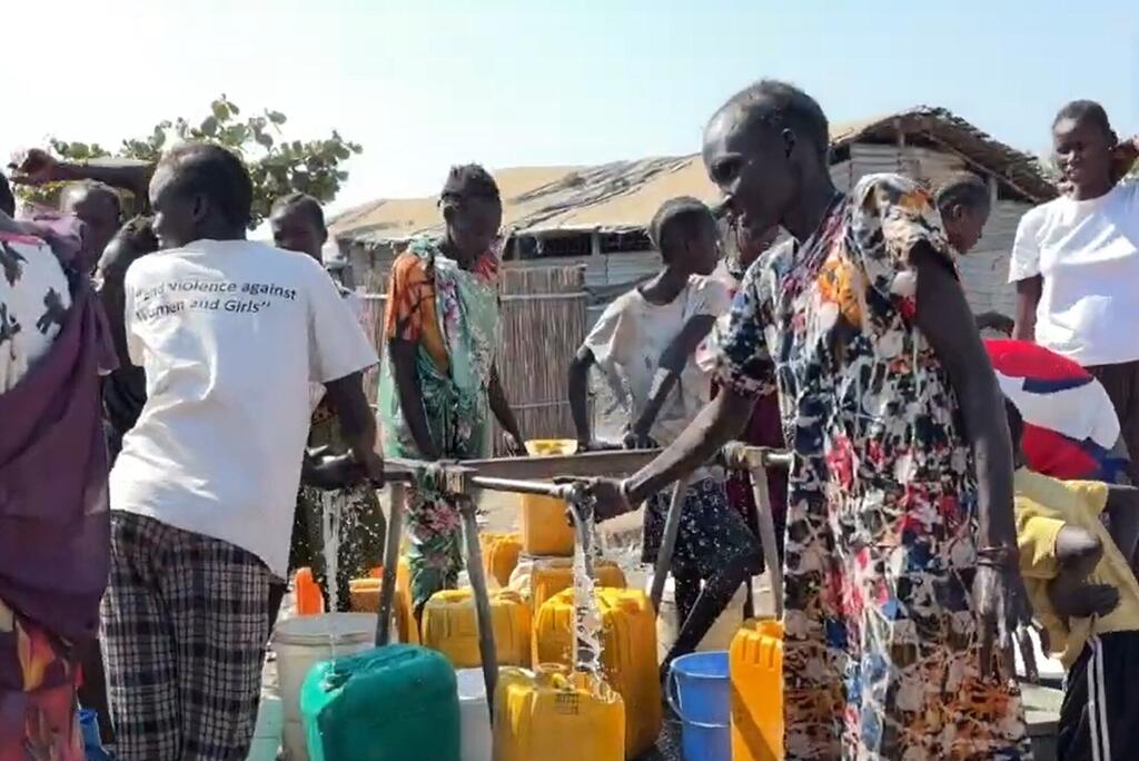 Wanawake na wasichana wakikusanya maji kwenye pampu huko Bentiu, Sudan Kusini, kama sehemu ya juhudi za misaada ya kibinadamu za UNMISS.