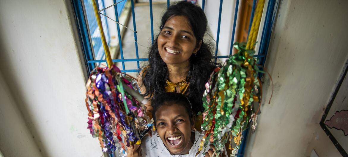 Retrato de Asha Sahoo, una 'Saheli', y Silu Pradhan, una 'Sakhi' del grupo ADVIKA, sonriendo alegremente en un columpio decorado en Sahaspur, Odisha, India.
