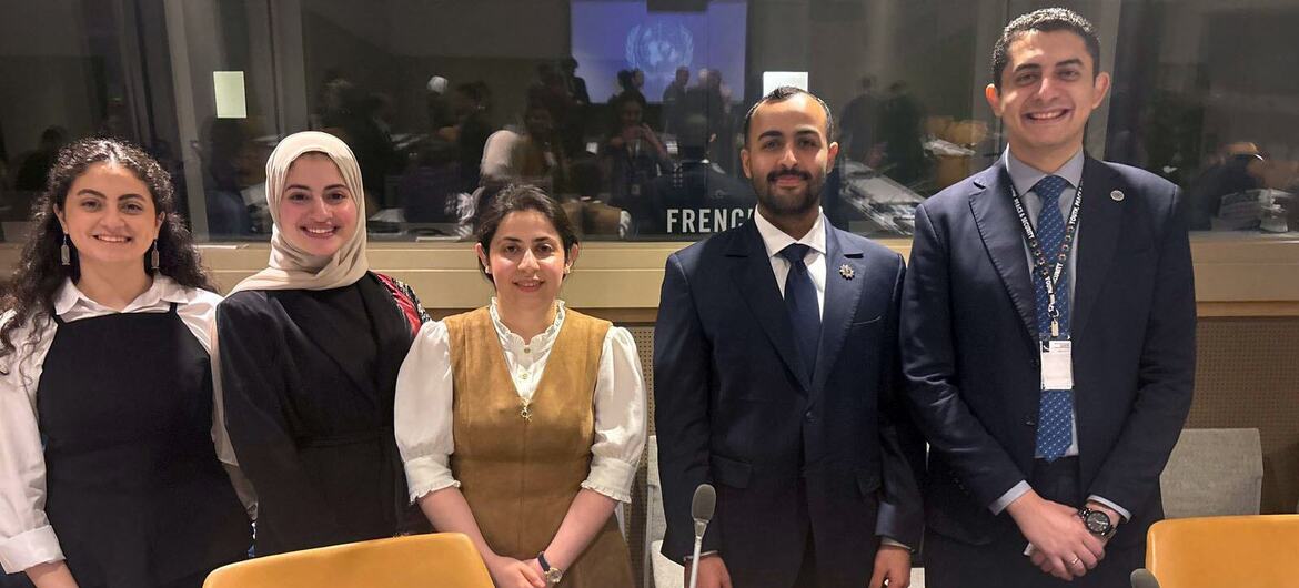 خمسة شباب مصريين، ثلاثة نساء ورجلان، يظهرون في صورة خلال مؤتمر للأمم المتحدة. يرتدون ملابس رسمية، بما في ذلك بدلات وحجاب، ويقفون خلف طاولة مزودة بميكروفونات.