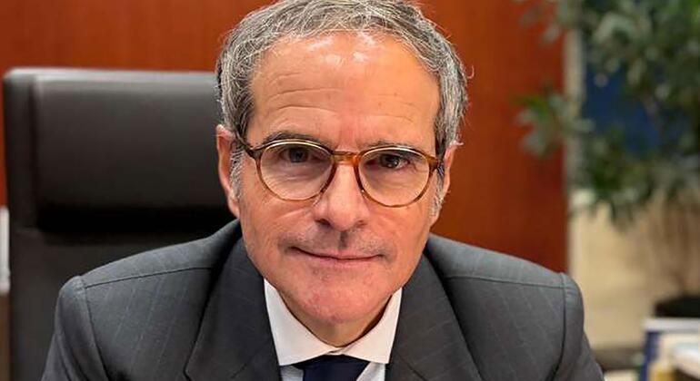 Портрет Рафаэля Мариано Гросси из Аргентины, сидящего в офисе, в костюме и очках.