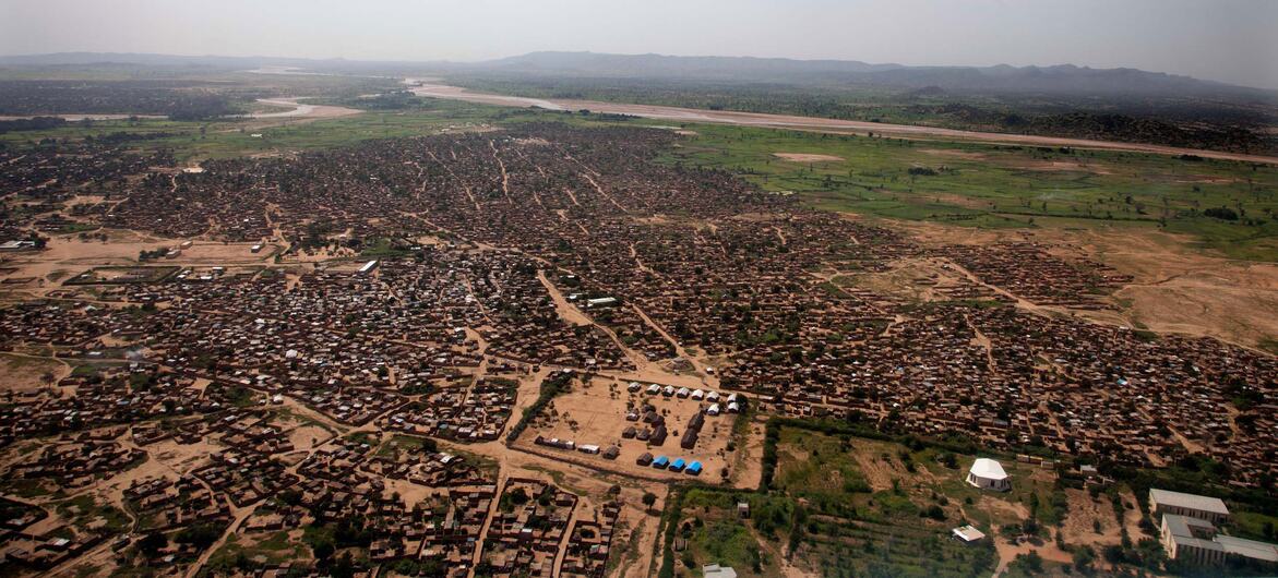 Aerial view of Zalingei city in Central Darfur, Sudan, showing a sprawling settlement with mud-brick buildings, surrounded by arid land and a river in the distance, captured on 18 September 2013.