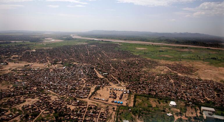 Аэрофотосъемка города Залингей в Центральном Дарфуре, Судан, показывает расширяющееся поселение с кирпичными зданиями, окруженное засушливой землей и рекой в дальнем расстоянии, снято 18 сентября 2013 года.