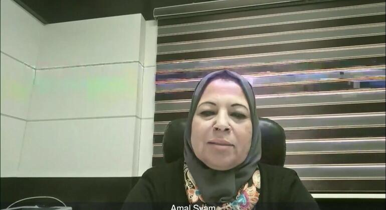 Photo of Amal Syam, a business professional in the Middle East, sitting in an office chair against a modern office background with umbrellas.