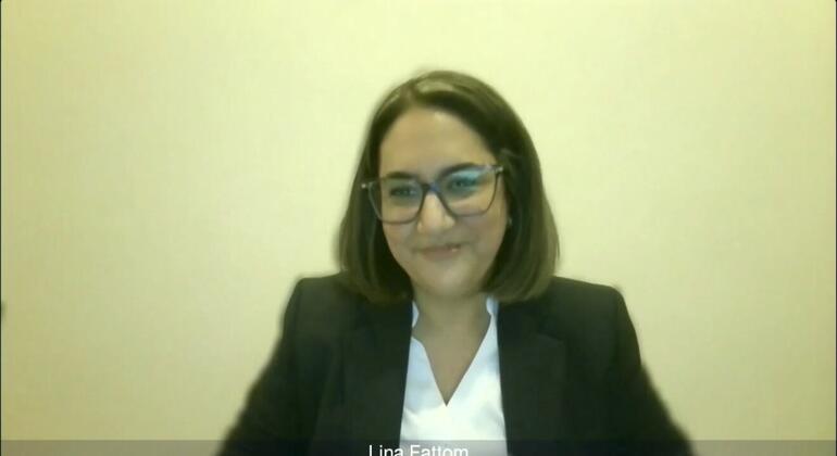 A screenshot showing a woman named Lina Fatem in a video call. She has black hair, wears glasses, wears a black jacket over a white shirt, and is smiling at the camera.