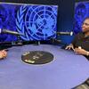Wanawake weusi wawili wameketi kwenye meza ya mviringo katika studio ya redio, wakizungumza kwa kutumia maikrofoni. Nyuma kuna skrini kubwa zinazoonyesha nembo ya UN Women kwa rangi ya bluu.