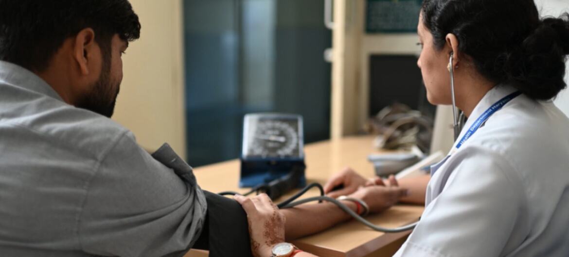Un professionnel de la santé en Inde vérifie la pression artérielle d'un patient en utilisant un dispositif sans mercure, soulignant l'initiative de l'OMS pour un équipement médical sans mercure.