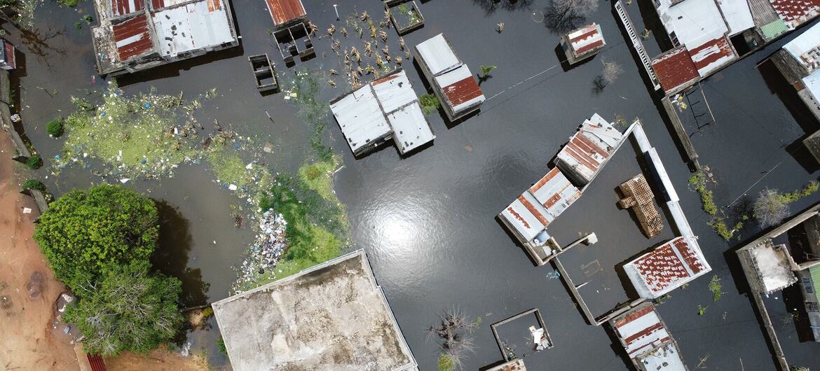 Imagem aérea de um drone do bairro de Magoanine, na cidade de Maputo, Moçambique, mostrando sérios danos causados por inundações com casas submergidas e detritos. Esta imagem captura o impacto das inundações catastróficas de janeiro de 2026, que afetaram centenas de milhares de pessoas e levaram a esforços nacionais de resposta de emergência pelo PMA e outras organizações humanitárias.