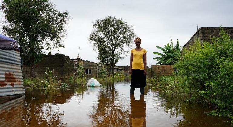 Celeste Zunguza está entre as águas da inundação no bairro Magoanine da cidade de Maputo, Moçambique, afetado por fortes inundações em janeiro de 2026. A imagem capta o impacto do desastre, com casas submersas e vegetação parcialmente submersa.
