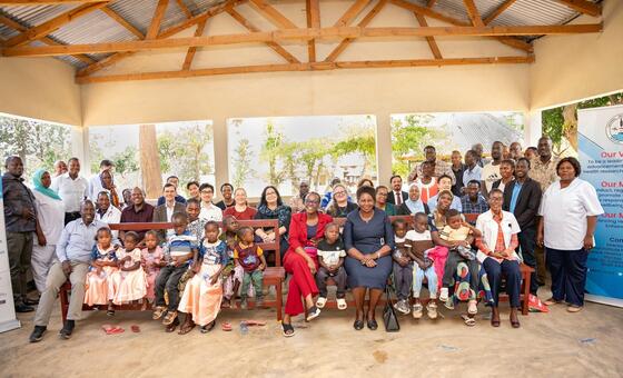 Picha ya kikundi cha watu wazima na watoto waliokusanyika kwa ajili ya mpango wa afya huko Mwanza, Tanzania, chini ya mpango wa STEPPS wa UNDP.