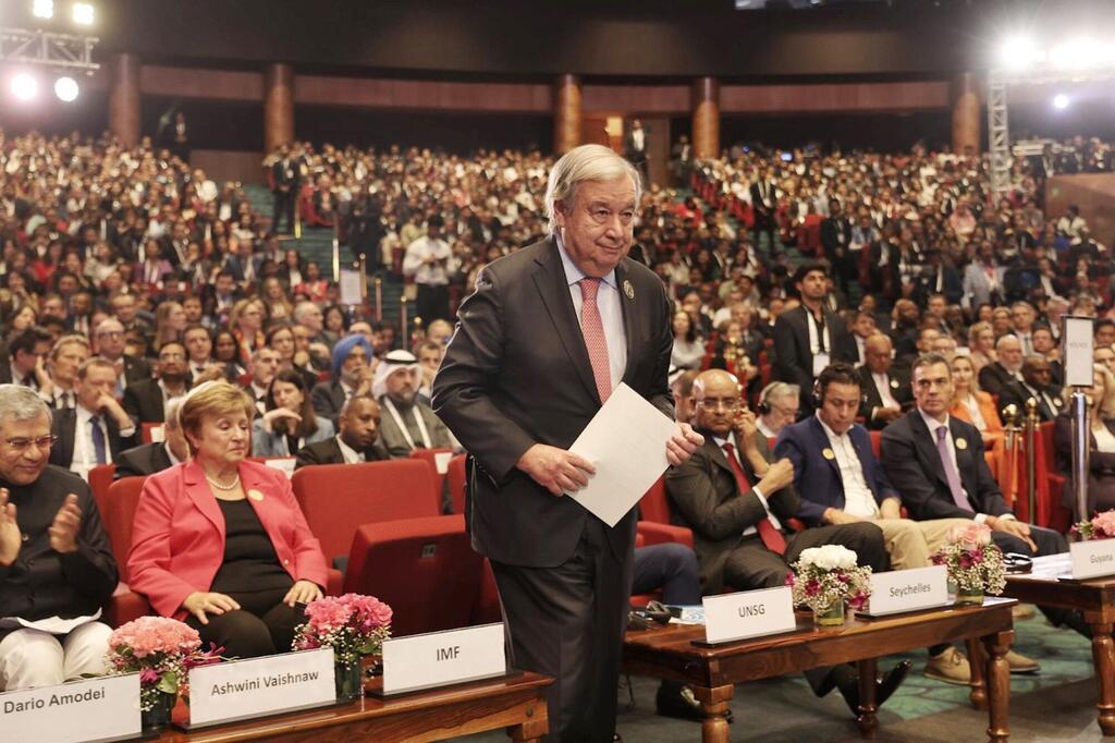 Katibu Mkuu wa Umoja wa Mataifa akizungumza katika Mkutano wa Athari za AI nchini India, akiwa amezungukwa na wajumbe wa kimataifa na watazamaji wengi.