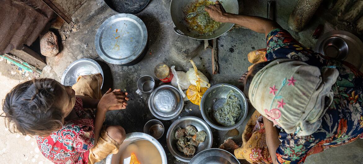 Overhead view of a pregnant Rohingya woman cooking food for her family in a camp in Sittwe, Myanmar.