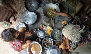 सिटवे, म्यांमार में एक शिविर में एक गर्भवती रोहिंग्या महिला अपने परिवार के लिए खाना बना रही है।