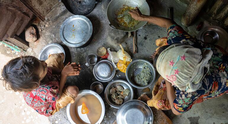 Overhead view of a pregnant Rohingya woman cooking food for her family in a camp in Sittwe, Myanmar.