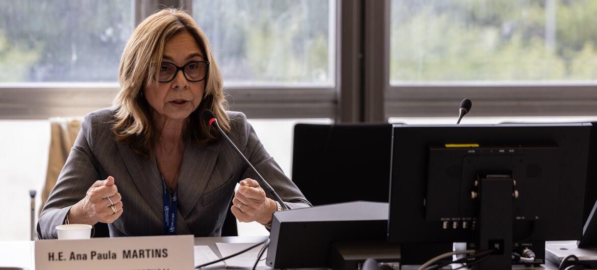 Ana Paula Martins, Ministra da Saúde de Portugal, falando num pódio durante uma reunião da OMS.