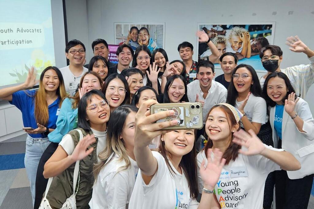 Felipe Paullier, Secretario General Adjunto para Asuntos de la Juventud, toma una selfie con un grupo de jóvenes defensores en Tailandia durante un evento de participación juvenil.