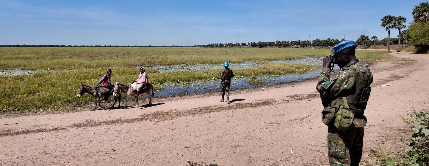MINUSCA peacekeeping troops survey the open border between Central African Republic and Sudan, while villagers, including women on donkeys, and armed men cross freely.