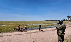 MINUSCA peacekeeping troops survey the open border between Central African Republic and Sudan, while villagers, including women on donkeys, and armed men cross freely.
