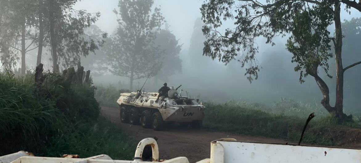 A UN peacekeeping vehicle travels along a foggy jungle road in the Democratic Republic of the Congo, highlighting the challenging duty stations of UN Volunteers.