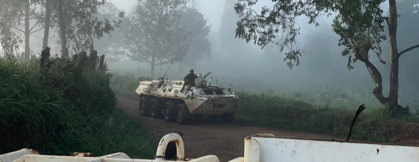Un véhicule de maintien de la paix de l'ONU traverse une route brumeuse dans la jungle de la République démocratique du Congo, mettant en évidence les tâches difficiles des bénévoles de l'ONU.