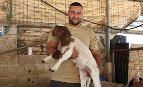 Mkulima katika Ukingo wa Magharibi, akiwa na kondoo mchanga, akionesha mazoea ya kilimo yanayoungwa mkono na FAO.