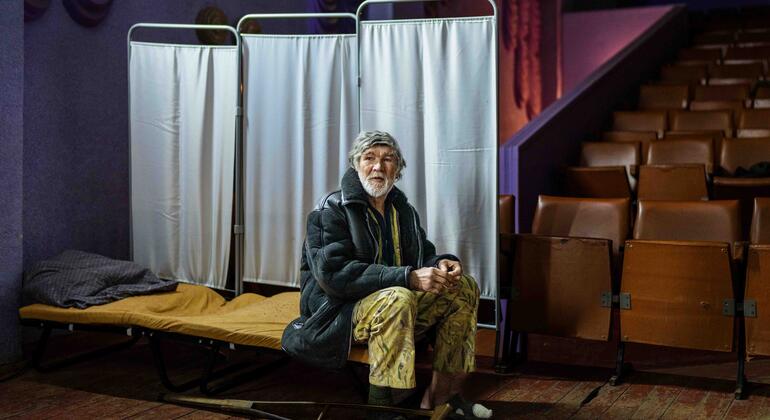 Пожилой украинский беженец в приюте, оборудованном в кинотеатре.