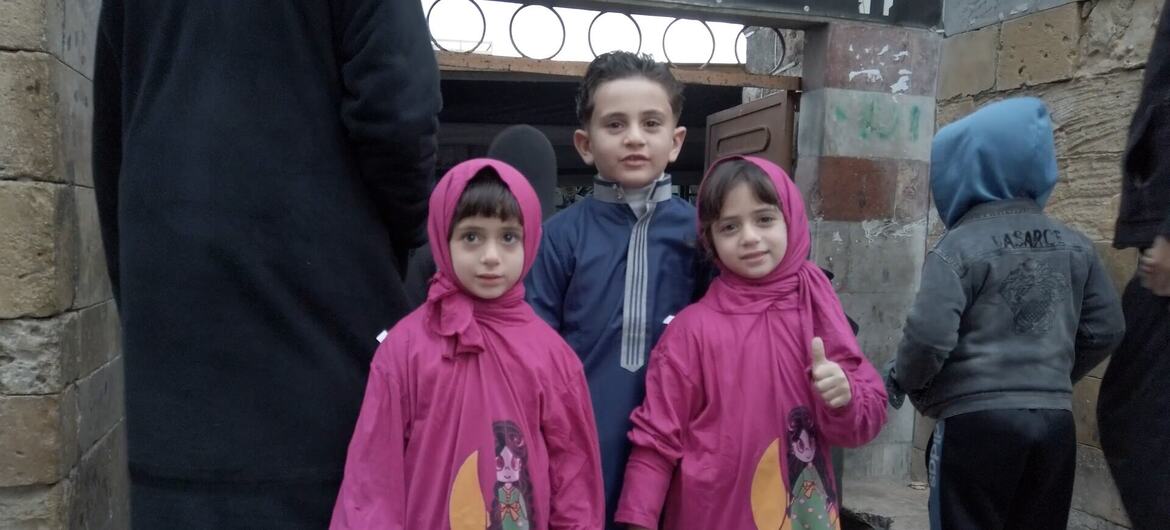 ثلاثة أطفال فلسطينيين يصلون مع أسرهم إلى  المسجد العمري الأثري في البلدة القديمة بمدينة غزة لأداء صلاة العيد مع أسرهم.