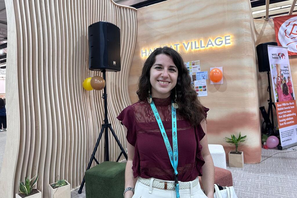 Paula Sevilla, del Instituto Internacional para el Medio Ambiente y el Desarrollo, sonríe en un stand de Habitat Village en un foro urbano.