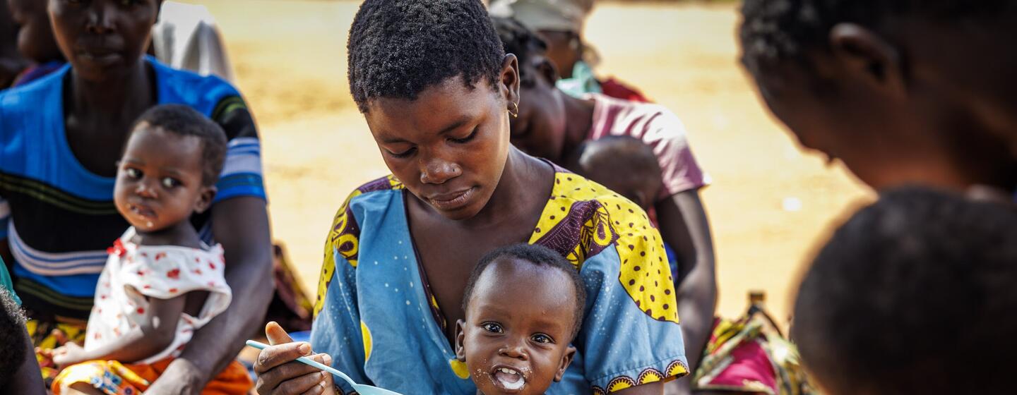Uma mãe alimenta seu bebê com uma colher durante um evento da brigada de saúde móvel no distrito de Chiure, província de Cabo Delgado, Moçambique, em abril de 2025.