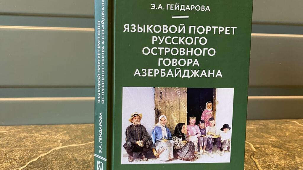 Зеленая книга Е.А. Гейдаровой «ЯЗЫКОВОЙ ПОРТРЕТ РУССКОГО ОСТРОВНОГО ГОВОРА АЗЕРБАЙДЖАНА» с фотографией семьи, состоящей из нескольких поколений, в традиционной одежде.